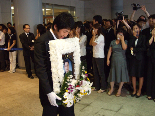 형의 영정을 들고 나오는 동생 심효민씨. 